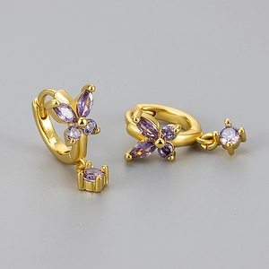 Detail of gold butterfly hoop earrings featuring purple zircon stones and drop pendant