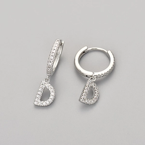 Close-up of letter D hoop earrings in silver finish with pavé set white zircon stones