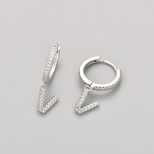 Detail of silver drop earrings with pavé cubic zirconia V charm and sparkling stones