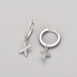 Detailed view of silver hoop earrings with shimmering X-shaped micro-pave charms