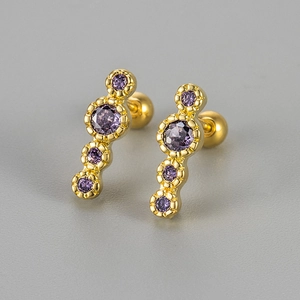Macro detail of gold bar earrings featuring four purple zircons with screw ball backs