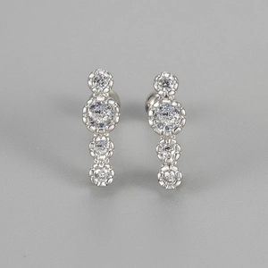 Close-up of silver stud earrings with four graduated round cubic zirconia stones