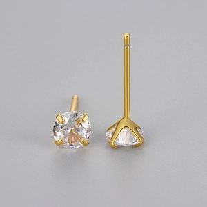 Gros plan détaillé des boucles d'oreilles en zircone avec monture à 4 griffes dorées