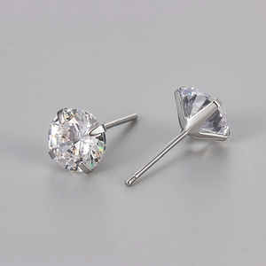 Détails de boucles d'oreilles argentées avec des zircons brillants à la taille ronde