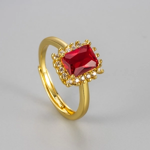 Macro view of adjustable gold-plated ring with rectangular red zircon and halo setting