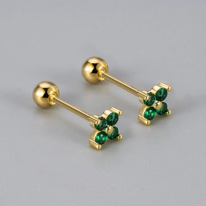 Detailed macro view of gold four-leaf flower earrings with green zirconia and screw backs