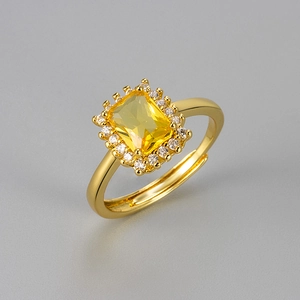 Detailed macro view of an adjustable gold ring with a large rectangular yellow zircon stone