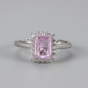 Detail of a rectangular pink gemstone ring with white zircon halo on a silver band