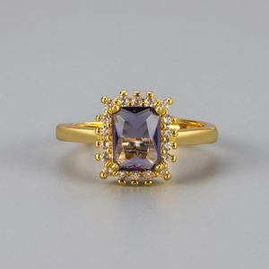 Macro shot of rectangular violet zircon ring with halo crystals and gold band detail