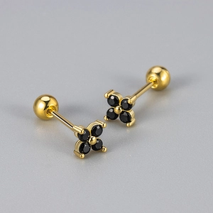 Macro view of gold flower earrings with black stones and screw back closure