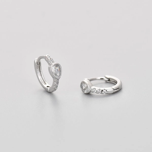 Detail van zilveren S925 huggie oorbellen met peervormige zirkoon en diamantaccenten