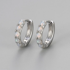 Elegant silver opal hoop earrings featuring five round iridescent stones on gray background