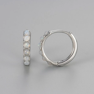 Detailed macro view of S925 silver hoop earrings with shimmering white opal stones