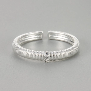Detailed view of silver textured band ring with engraved stripes and two zircon stones