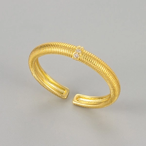 Close-up of gold textured ring with striped metal carving and two small white zircons