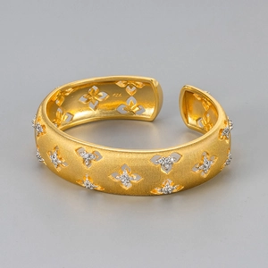 Vintage brushed gold cuff bangle with cutout clover pattern and zircon accents