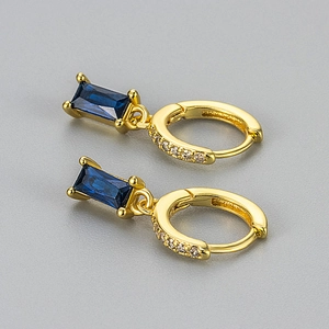 Detail von goldenen Creolen mit rechteckigen blauen Zirkonia und Mikro-Pave-Kristallen