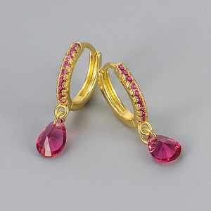 Detail of gold hoop earring with pavé stones and a pear-cut pink zircon drop