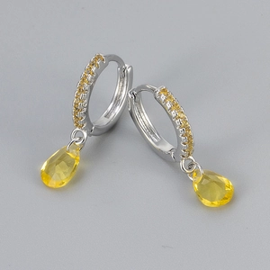 Detail view of silver drop earrings with yellow pear-cut zircon and pavé setting