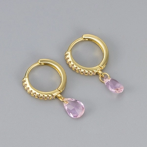 Close-up of golden hoop earrings with pink teardrop crystals and pavé micro-inlay