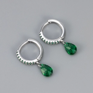 Detail of silver hoop earrings featuring green teardrop zircon and pavé crystals