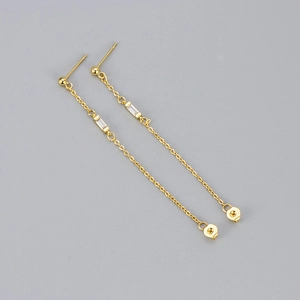 Minimalist gold chain tassel earrings with rectangular cubic zirconia on a grey background