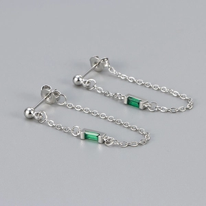 Detail of silver chain earrings featuring rectangular green zircon and minimalist design