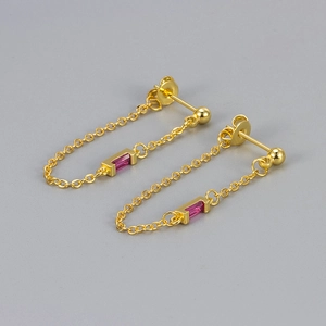 Detail of gold chain tassel earrings with rectangular pink zircon in a curved drop design