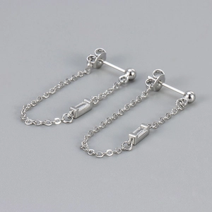 Macro detail of silver tassel earrings with delicate chains and rectangular cubic zirconia