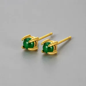 Dettaglio di orecchini a lobo dorati da 4,5mm con pietre rotonde verde smeraldo