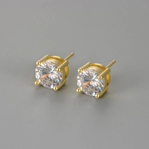 Detail of four-prong gold earring with sparkling round clear cubic zirconia stone