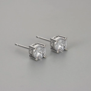 Minimalist four-prong round zircon stud earrings with polished silver metal finish