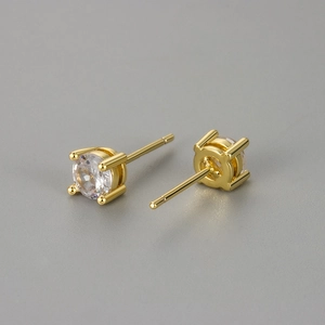 Macro shot of 4-prong round cubic zirconia stud earrings with a polished gold finish