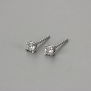 Macro shot of silver four-prong stud earrings with round-cut sparkling cubic zirconia
