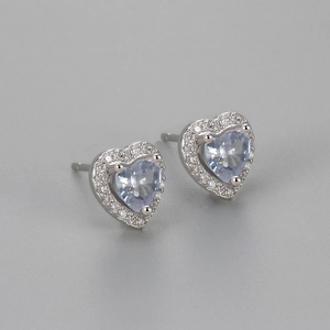 Macro view of heart-shaped earrings with purple zircon and silver-toned halo settings