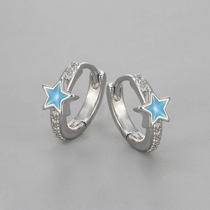 Macro detail of silver star hoop earrings featuring blue enamel and white zircon stones