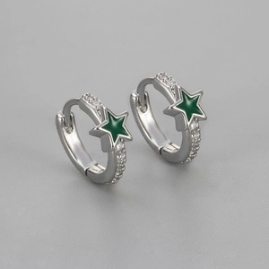 Detailed macro view of silver star hoop earrings with green enamel and white zircon stones