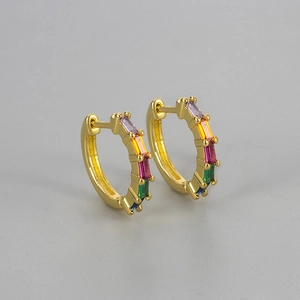 Close-up of golden huggie earrings with five colorful rectangular zircon rainbow stones