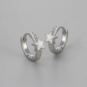 Macro detail of silver star hoop earrings with white enamel and sparkling zircon pave