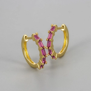 Close-up of gold-plated hoop earrings with rectangular pink cubic zirconia stones