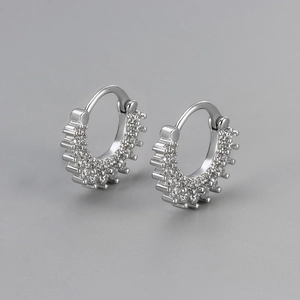 Vue détaillée de boucles d'oreilles créoles argentées serties de zircons forme soleil