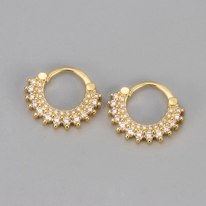 Détail de boucles d'oreilles créoles dorées ornées de deux rangées de cristaux de zircon