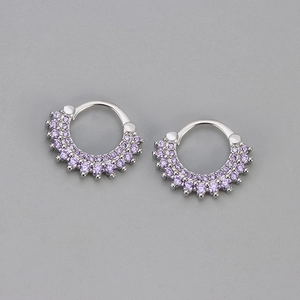 Gros plan sur des créoles en argent avec deux rangées de zircons violets sertis de griffes
