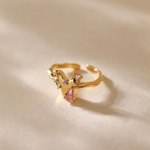 Dettaglio dell'anello in oro 18K con zircone rosa e fascia dalla texture ondulata