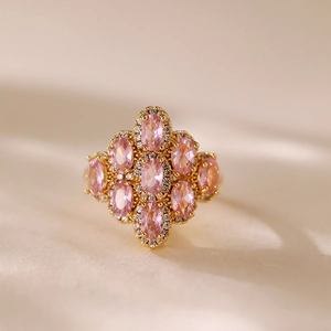 Dettaglio macro di anello placcato oro con zirconi rosa ovali e cristalli brillanti