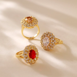 Macro di anelli placcati in oro con pietre di zircone ovali color champagne, bianco e rosso