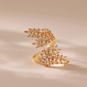 Dettaglio macro dell'anello dorato a forma di foglia con pietre di zircone taglio marquise