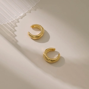 Bagues d'oreilles minimalistes dorées en C avec texture facettée géométrique et fini brillant