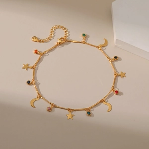 Detail van de 18K vergulde enkelband met kleurrijke emaille ster- en maanhangers