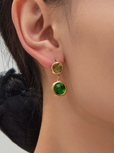 Detailed close-up of vintage gold double-drop earrings with green zircon gemstones